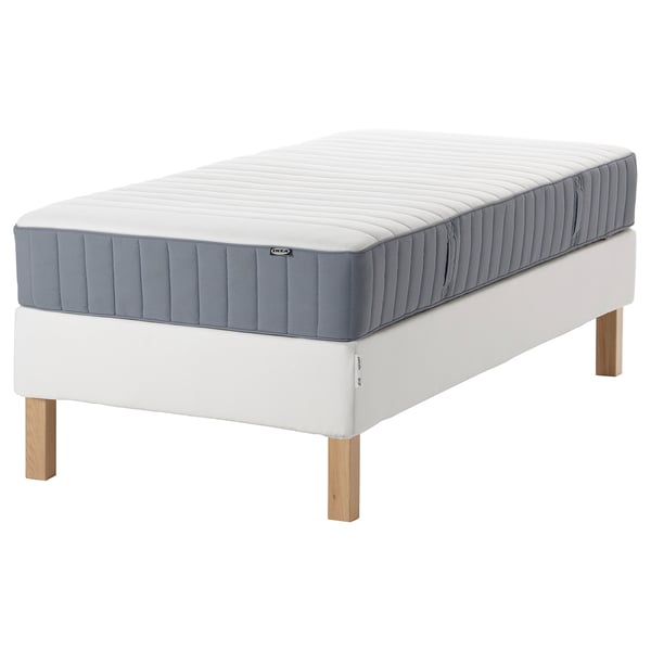 An IKEA ESPEVÄR/VALEVÅG bed in white, with a blue-gray mattress on a wooden base.
