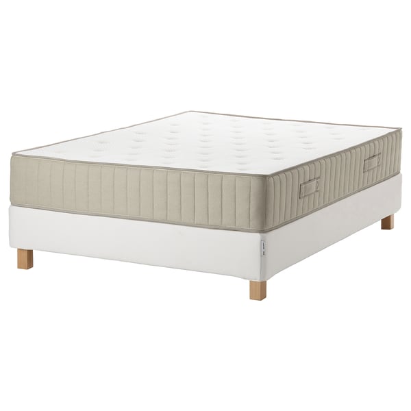 Shows a rectangular, white mattress with wooden legs and quilted design, showing base support.
