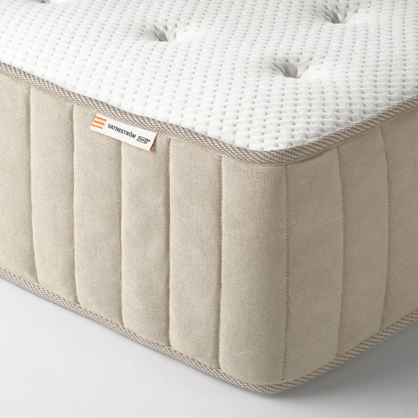 Close-up of a firm mattress with visible pocket springs and natural fabric, showcasing quality and comfort.