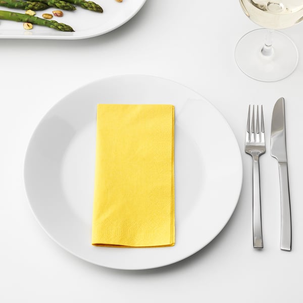 White dinnerware with yellow napkin, fork, knife, glass, and asparagus.