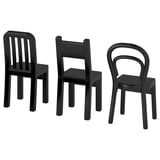 Three black miniature chairs, one with vertical slats, one with solid backrest, another with loop-shaped backrest, arranged side by side.