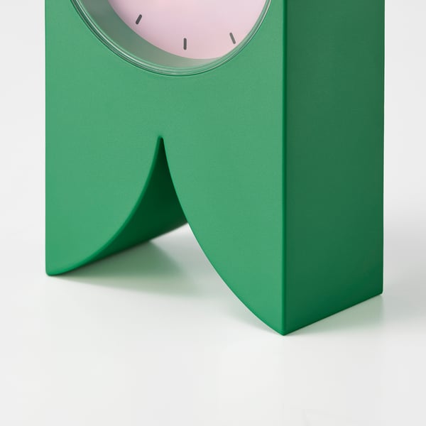 Green modern clock on stand; minimalist design.