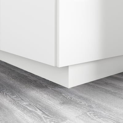 White kitchen cabinet base with plinth, covering gap between floor and cabinet.