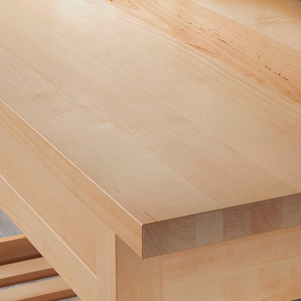 Close-up of smooth, light-colored wooden tabletop, showing high-quality finish and natural wood grain.