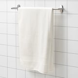 FREDRIKSJÖN white towel, thick & soft, hangs on wall rack. Pure cotton, large, with woven border detail.
