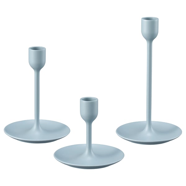 Three light blue, minimalist candlesticks in varying heights with round bases, arranged in a row.
