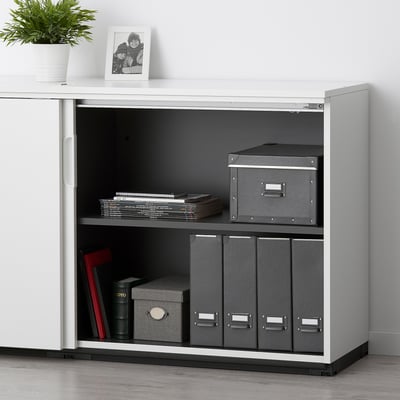 White GALANT cabinet with 2 shelves, combo lock, gray boxes, files, plant, photo.