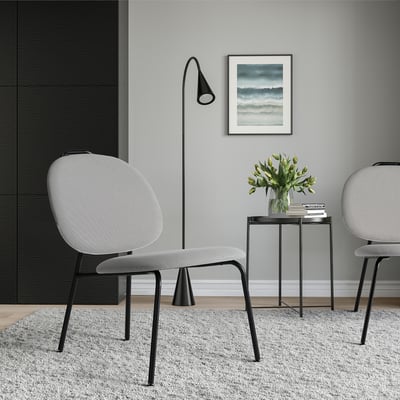 Modern minimalist living room with GÄVLE chair, side table & lamp.