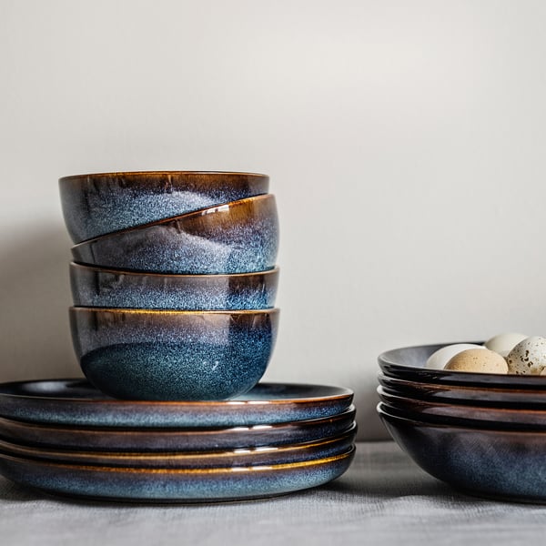 Ceramic bowls, ocean blue with gold rim, stacked neatly on table, decorative, handcrafted look.