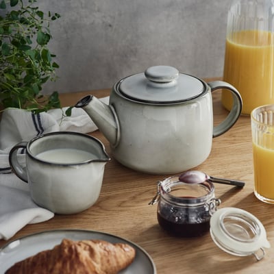 A GLADELIG teapot, white with a sandy glaze, made of stoneware, featuring classic and timeless design.