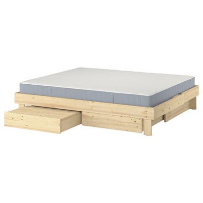 GLAMBERGET extendable bed in natural wood with white mattress and two storage boxes.