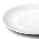 Elegant white porcelain plate with intricate geometric pattern, smooth edges, clean design.
