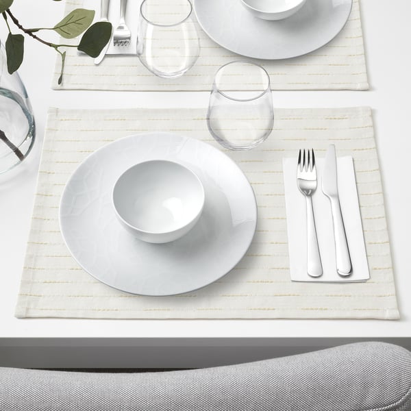 White porcelain table setting with plate, bowl, glass, cutlery, and napkin. Geometric design, arranged neatly.