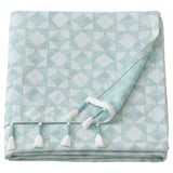 A folded GOKVÄLLÅ throw blanket. It is light blue with white accents, featuring a geometric pattern and handmade tassels along the edge.
