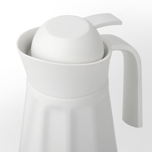 White insulated pitcher with a handle, featuring a removable lid and a curved spout for easy pouring.