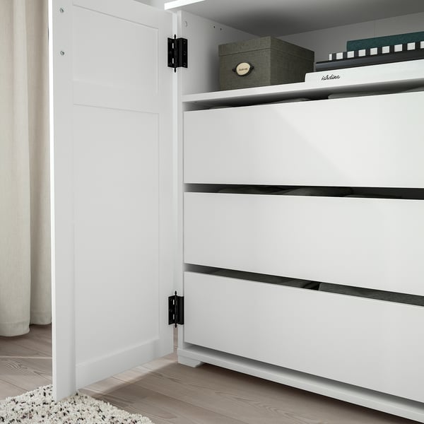 Modern white cabinet with three drawers and black handles, showing secure door stop and floor anchoring.