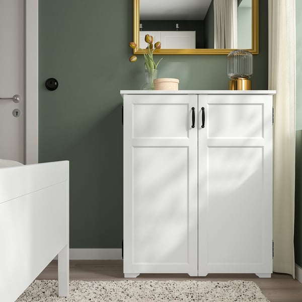 White GREÅKER cabinet with 2 doors, countertop, vase, lamp, mirror, cozy bedroom.