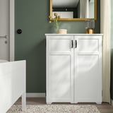 White GREÅKER cabinet with 2 doors, countertop, vase, lamp, mirror, cozy bedroom.