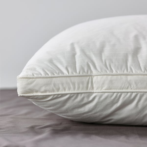 Pillow with smooth cotton cover and supportive core, resting on bed.
