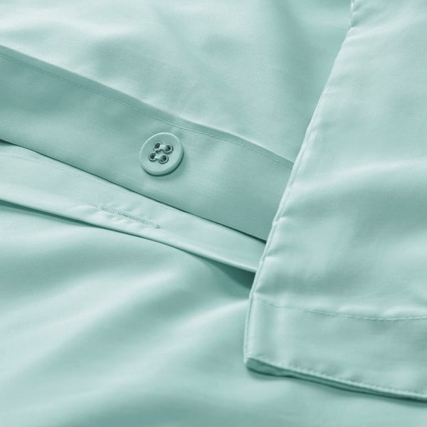 Light turquoise duvet cover with piping and button. Pillowcase has envelope closure. Made of soft, absorbent lyocell fabric.