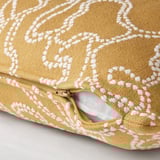A yellow cushion cover with a white pattern, partially unzipped to reveal its function.
