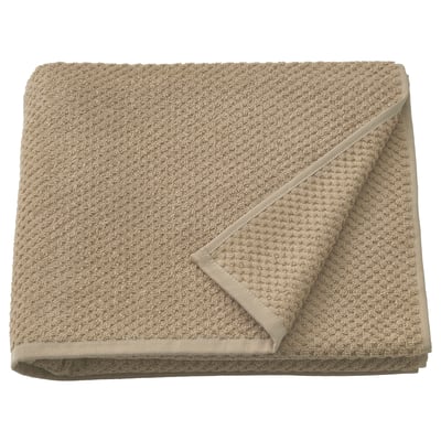 This image shows a beige GULVIAL towel, made of soft 100% cotton, folded neatly. Its thick, fluffy texture is visible.