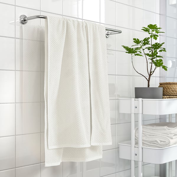 GULVIAL towel, beige, 100% cotton, medium-thick, soft, folded on holder, near white shelves.
