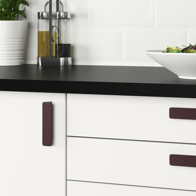 Two sleek, dark brown HACKÅS handles, rectangular with rounded edges, placed side by side on a white background.