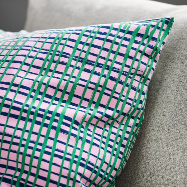 Colorful striped cushion on gray couch.