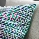 Colorful striped cushion on gray couch.