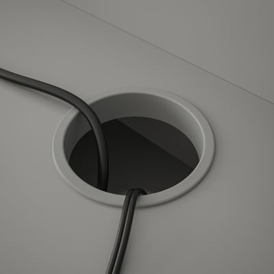 Circle cable grommet on desk, hiding and managing electric cables neatly.