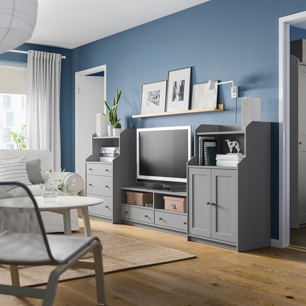 Gray HAUGA storage units in blue living room. Tv center with decor and plants.