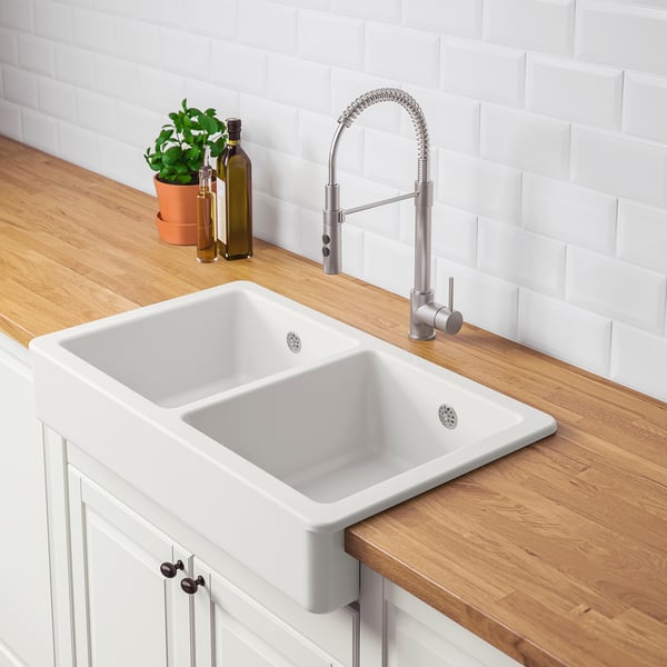 Modern kitchen sink with pull-down faucet. Double basin for efficient dishwashing and prep, set in rustic wooden countertop.