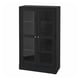 Black HAVSTA display cabinet with glass doors, showcasing items, combining rustic and modern design.