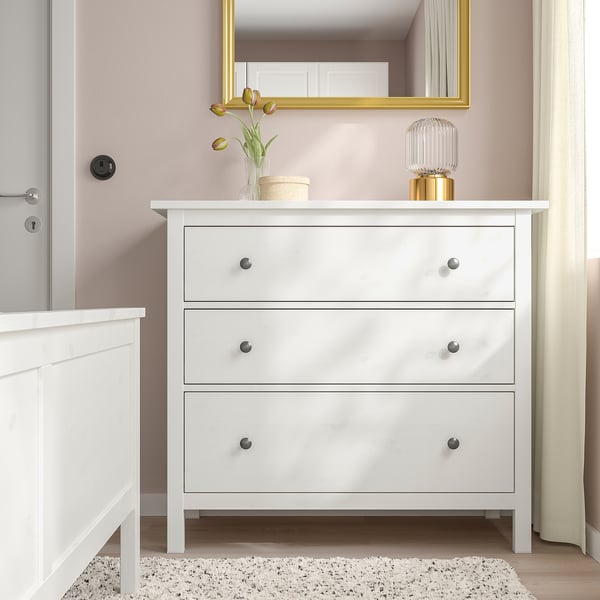 HEMNES chest drawers in bedroom, 3 drawers, against pink wall, near bed.