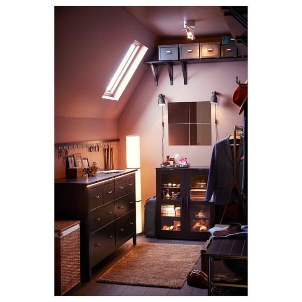 Wooden HEMNES chest with mirror in dark brown room, pink walls, skylight, wicker basket.