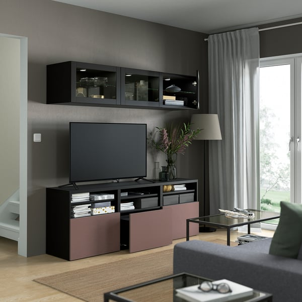 Modern living room with wall-mounted glass cabinets, flat-screen tv, and colorful media unit with storage.
