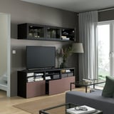 Modern living room with wall-mounted glass cabinets, flat-screen tv, and colorful media unit with storage.