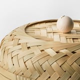 Elegant woven bamboo basket with herringbone pattern and lid, showcasing intricate craftsmanship.