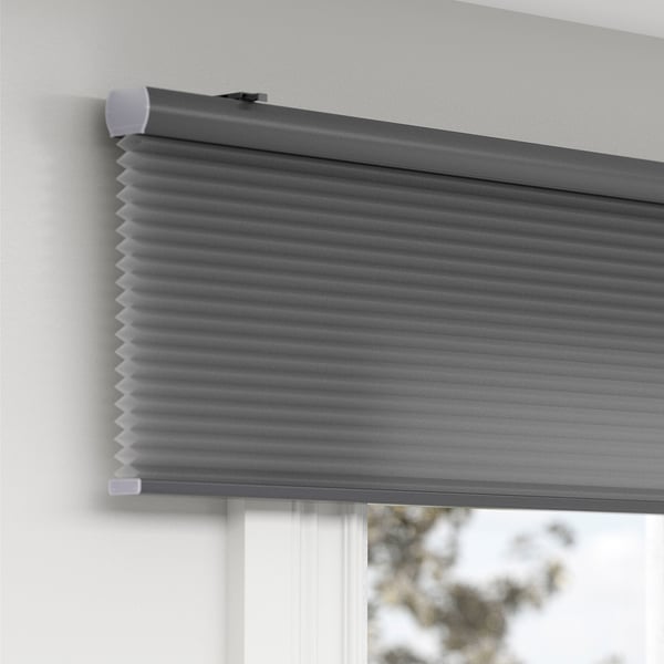 Gray room-darkening cellular blind with hidden cord, mounted on wall, providing privacy and insulation.