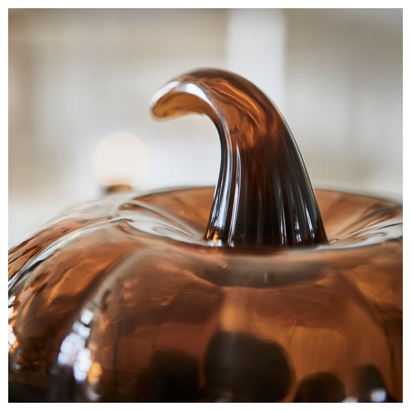 Brown glass pumpkin-shaped bowl with a sleek, curved handle, reflecting light to show high-quality craftsmanship and smooth finish.