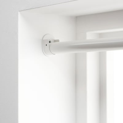 Close-up of a white bracket mounted high on a wall, designed to hold curtain rods securely between opposite walls.