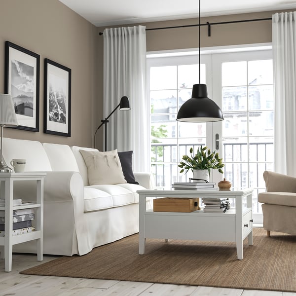 Modern living room with white coffee table and flowers.