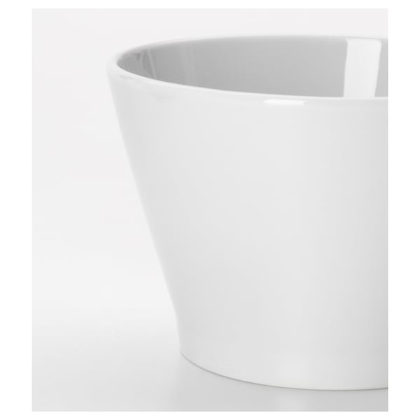 Sleek white porcelain bowl, smooth glaze, stacked on table.