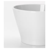 Sleek white porcelain bowl, smooth glaze, stacked on table.