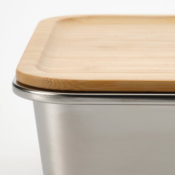 Close-up of a stainless steel container lid with a bamboo cover, showcasing a smooth and well-fitted design.