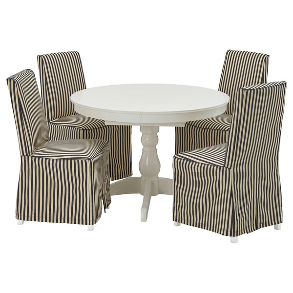 Round white dining table with four striped chairs. Elegant, classic design with modern comfort.