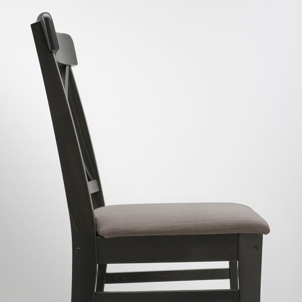 Modern black chair with sleek, curved design and cushioned seat. Part of durable, extendable dining set.