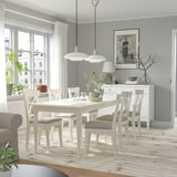 Dining room with INGATORP table, greenery, flowers, two lamps, and a large window.