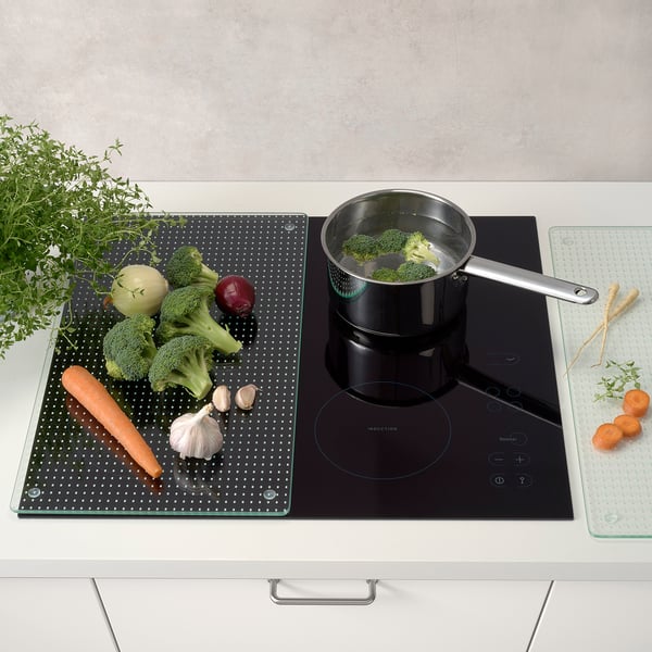 Broccoli simmers, veggies on mat, herbs nearby.